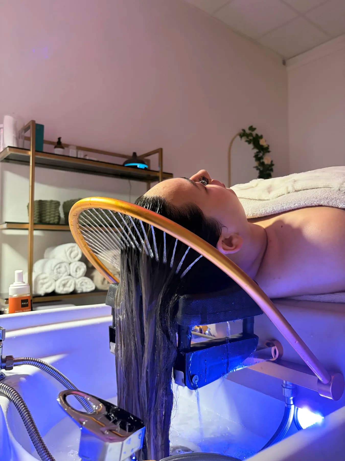 Head spa cradle bathed in pink and blue light